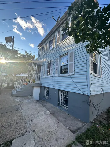 a view of a house with a yard and a large tree