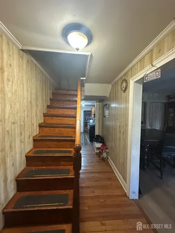 a view of a hallway with wooden floor and staircase