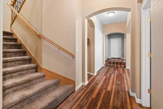 a view of a hallway with wooden floor and staircase