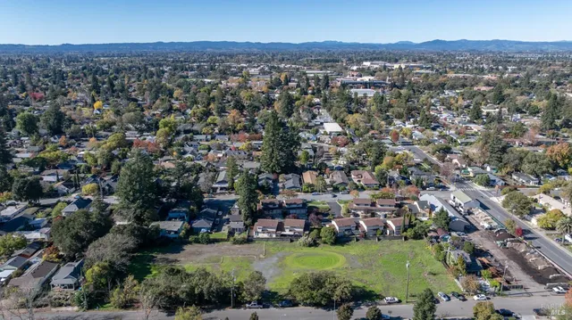 an aerial view of residential houses with outdoor space and trees