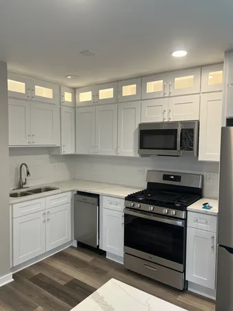 a kitchen with stainless steel appliances a stove a microwave and white cabinets