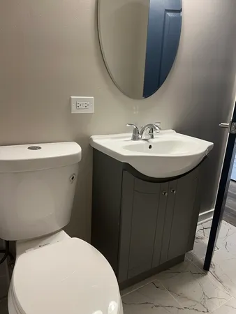 a bathroom with a toilet sink and mirror