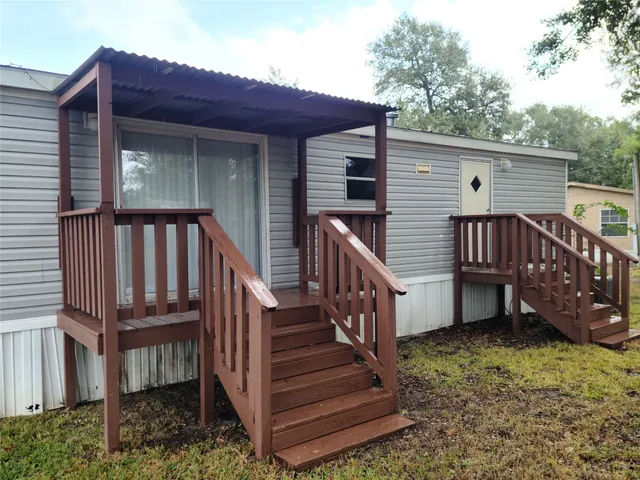 a view of a house with wooden deck and furniture