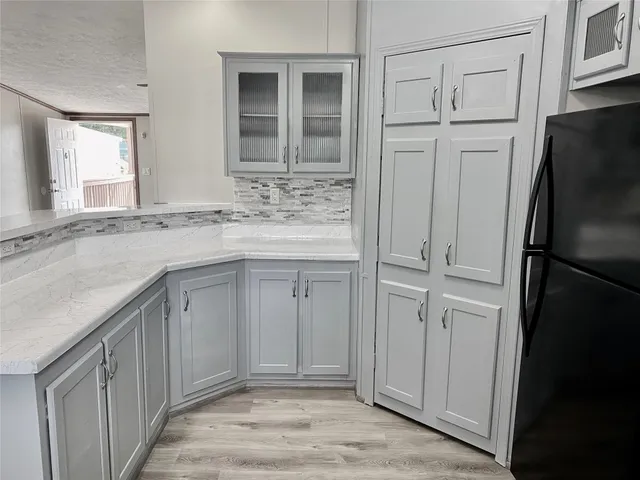 a bathroom with a granite countertop sink and a refrigerator