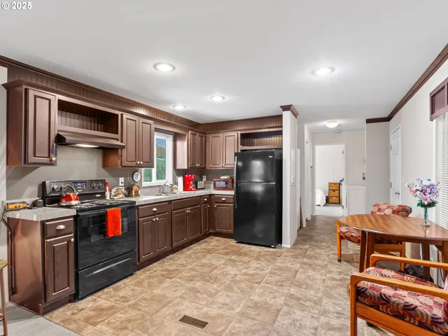 a kitchen with stainless steel appliances kitchen island granite countertop a refrigerator and a stove top oven