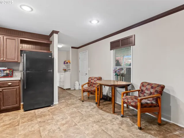 a dining room with furniture and a refrigerator