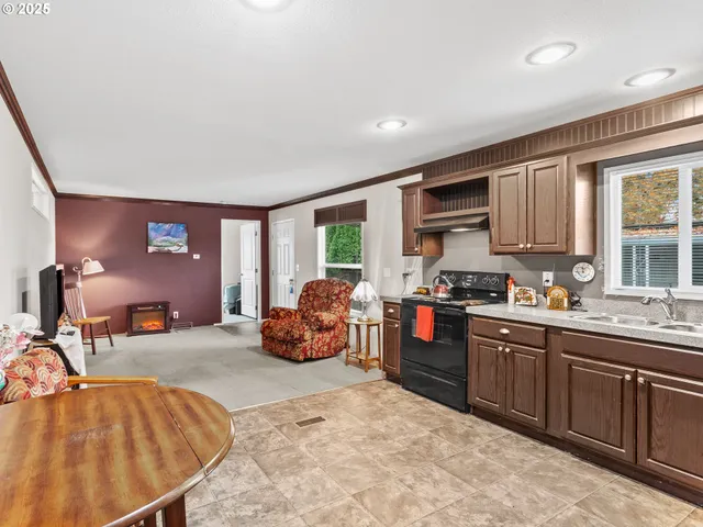 a large kitchen with stainless steel appliances granite countertop a stove a sink and a refrigerator