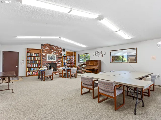 a living room with furniture and a flat screen tv with kitchen view