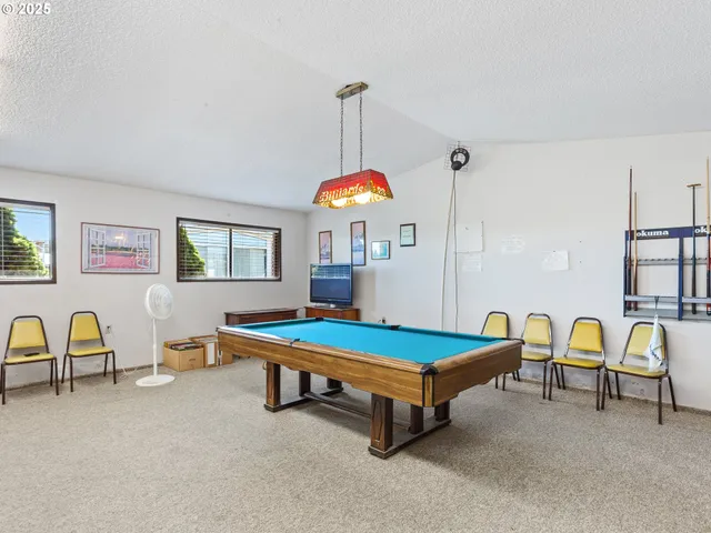 a room with pool table and windows
