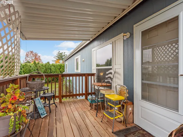 a balcony with wooden floor table and chairs