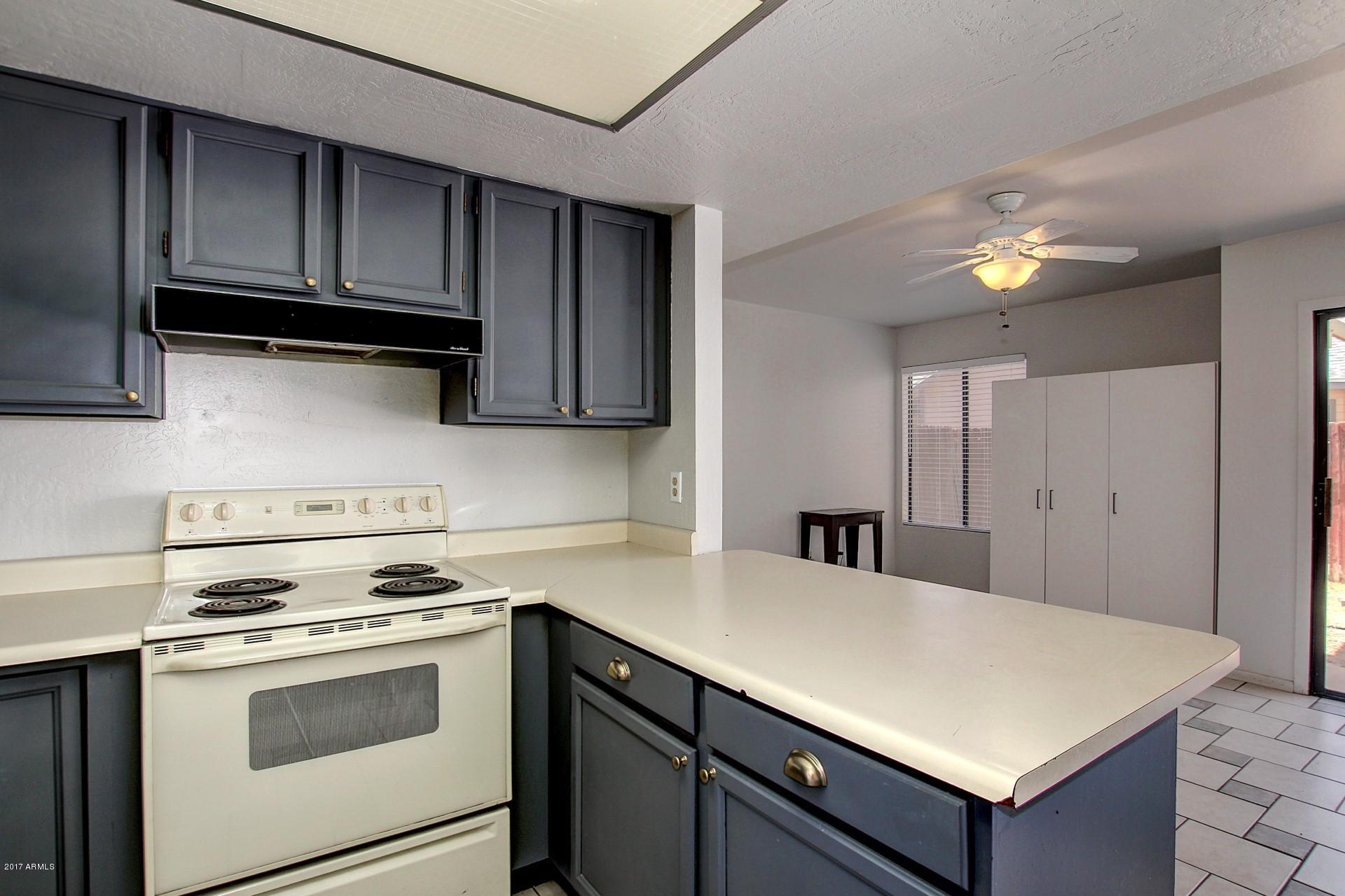 2455 East Broadway Road, Unit 93 Mesa, AZ 85204 - Photo 12 of 26 a kitchen with a stove cabinets and wooden floor
