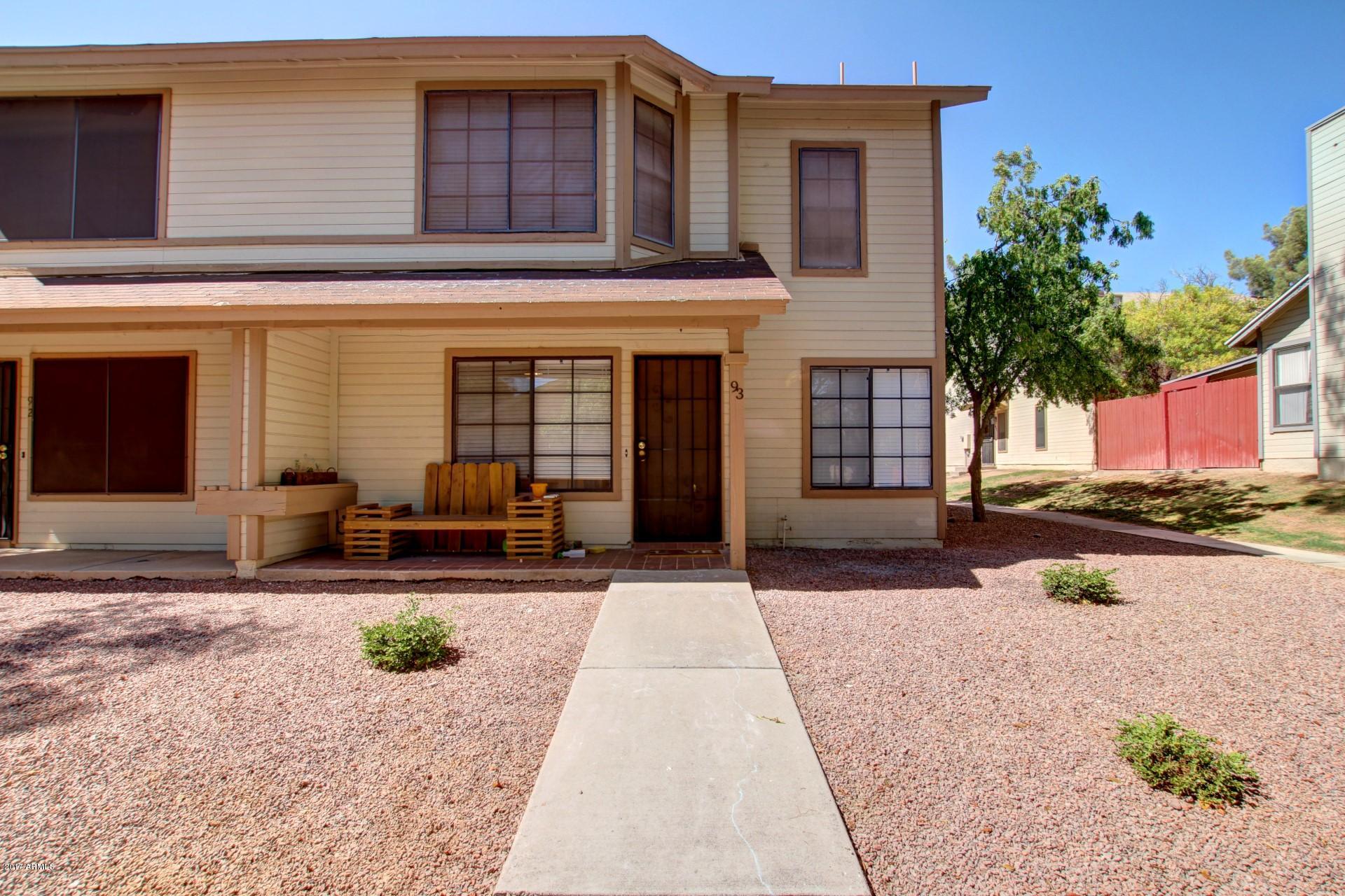 2455 East Broadway Road, Unit 93 Mesa, AZ 85204 - Photo 3 of 26 a front view of a house with outdoor seating and a forest