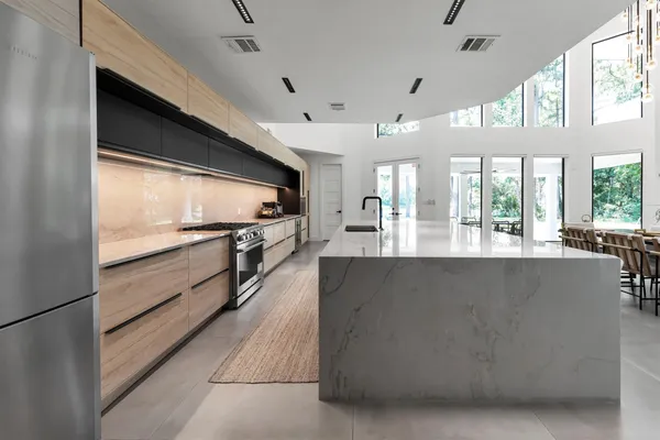 a large kitchen with stainless steel appliances kitchen island a large counter top