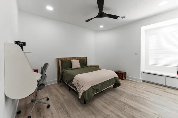a bedroom with a bed a desk and chair