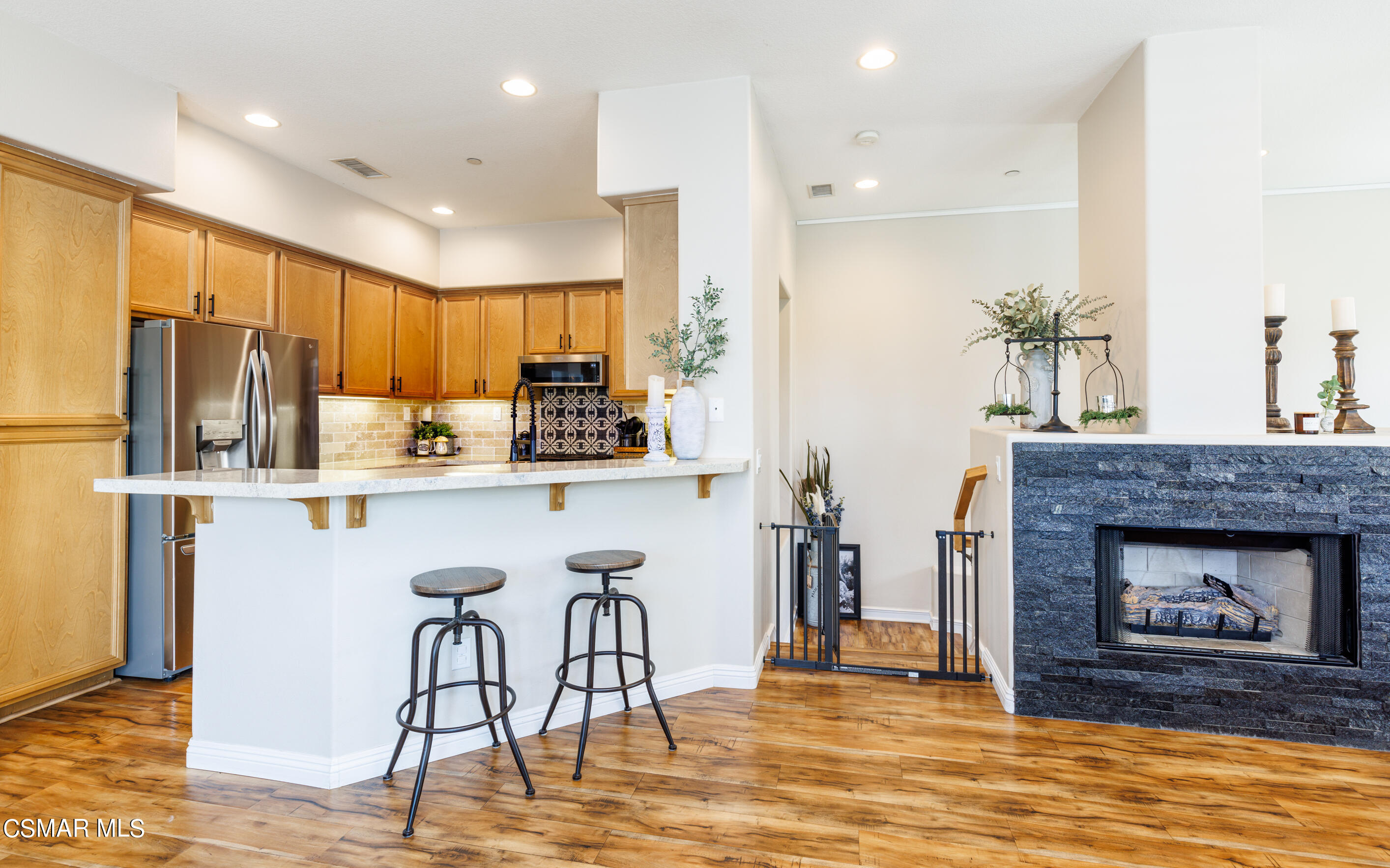 4121 Paredo Way, Unit A Simi Valley, CA 93063 - Photo 2 of 29 a kitchen with stainless steel appliances granite countertop a refrigerator a stove top oven and a fireplace with wooden floor