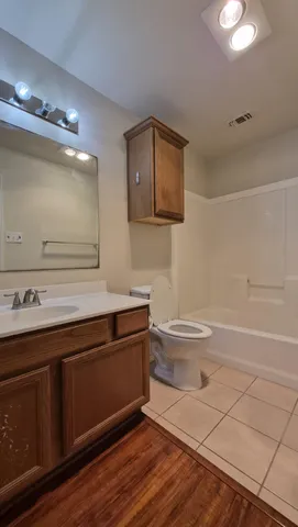 a bathroom with a toilet a sink and mirror