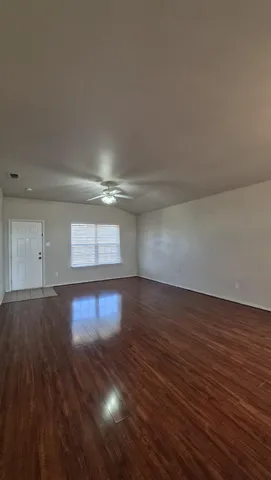 a view of empty room with wooden floor