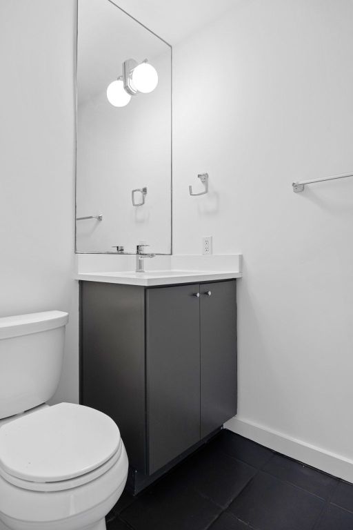 1200 Enfield Road, Unit 205 Austin, TX 78703 - Photo 10 of 22 a bathroom with a sink a toilet and a mirror