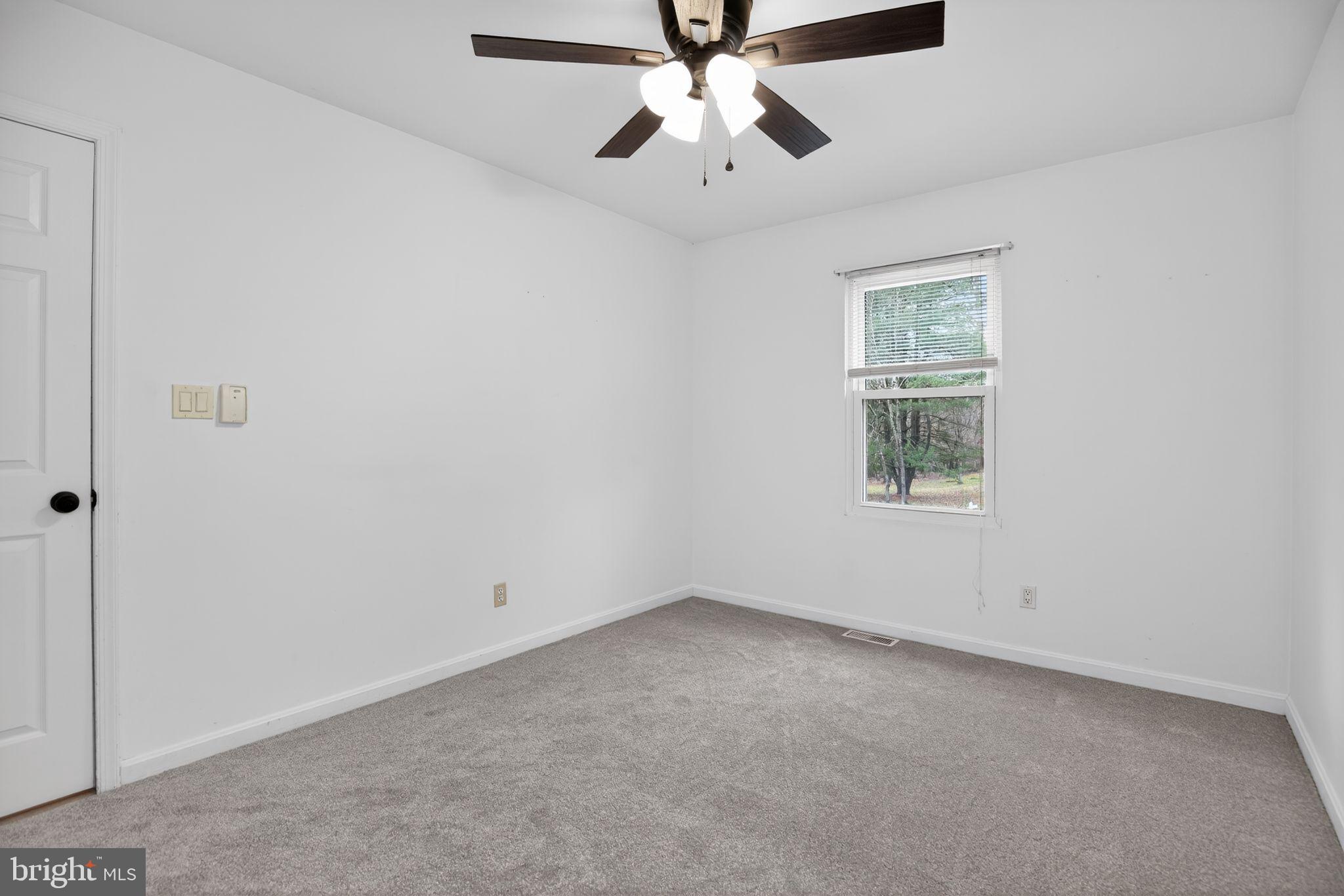 3240 Richfield Road Huntingtown, MD 20639 - Photo 12 of 33 an empty room with windows and fan