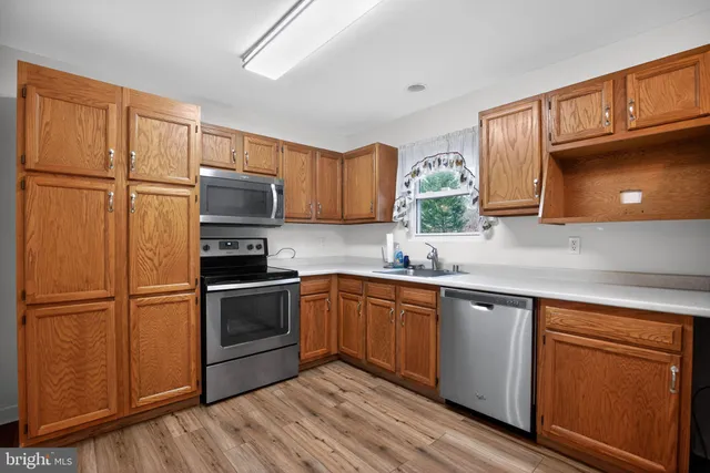 a kitchen with granite countertop stainless steel appliances and wooden cabinets