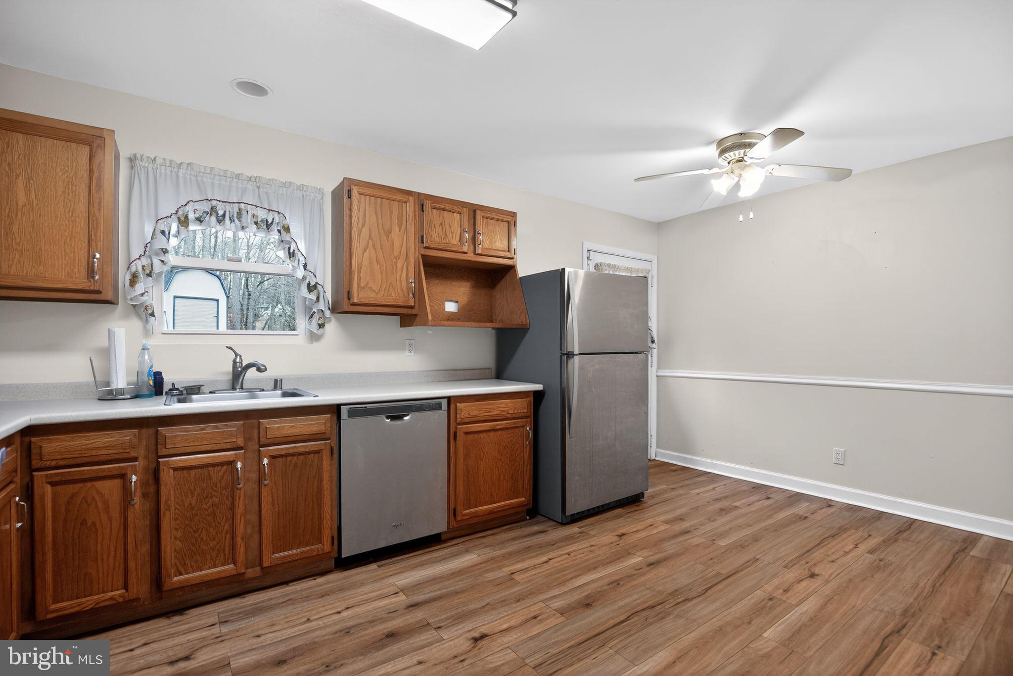 3240 Richfield Road Huntingtown, MD 20639 - Photo 7 of 33 a kitchen with stainless steel appliances granite countertop a sink a stove a refrigerator cabinets and wooden floor