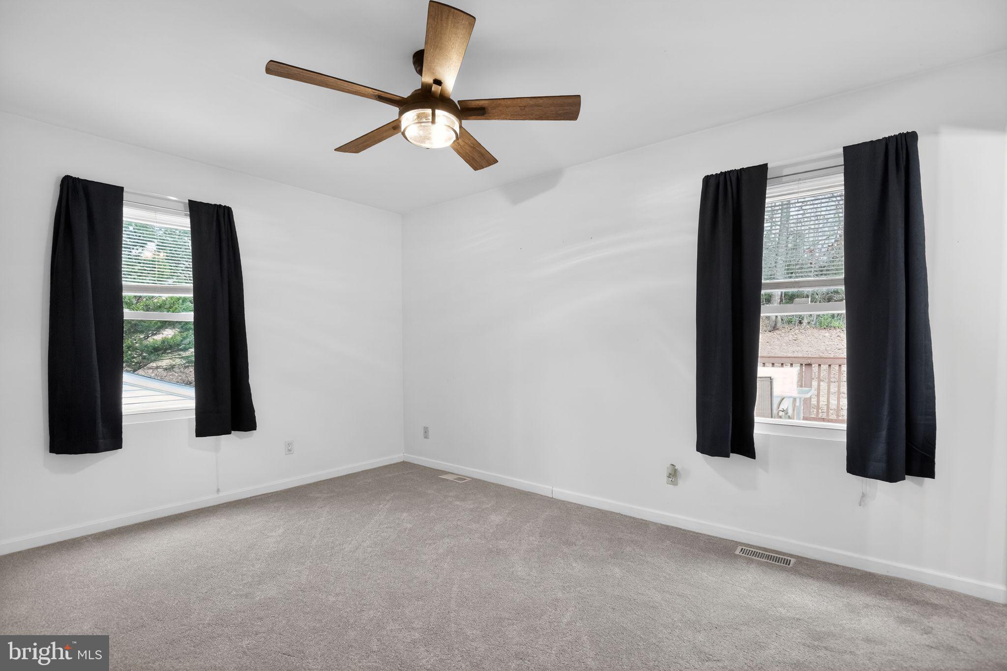 3240 Richfield Road Huntingtown, MD 20639 - Photo 8 of 33 an empty room with windows and fan