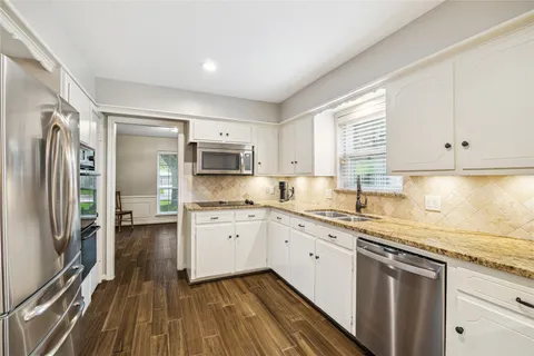 a kitchen with stainless steel appliances granite countertop a stove a sink and a refrigerator