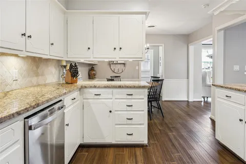 a kitchen with granite countertop white cabinets and white appliances