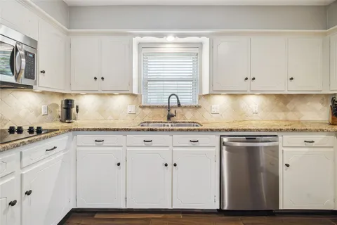 a kitchen with granite countertop white cabinets and white appliances