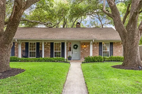 a front view of a house with yard and green space
