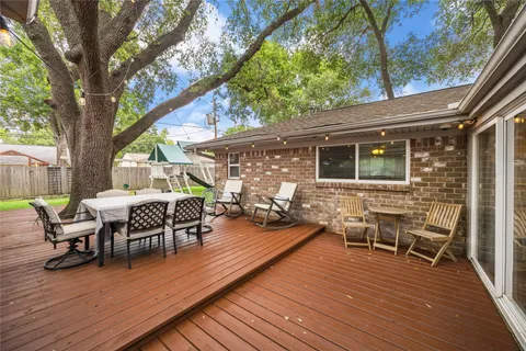 a view of a patio with table and chairs with wooden floor and fence