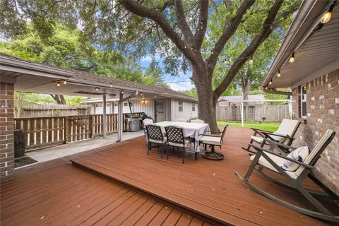 a view of a patio with a table chairs and a barbeque