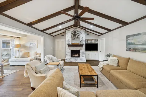 a living room with furniture a flat screen tv and a fireplace