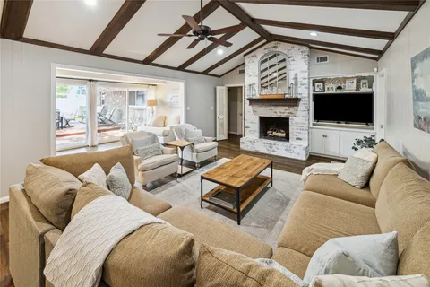 a living room with furniture a flat screen tv and a fireplace