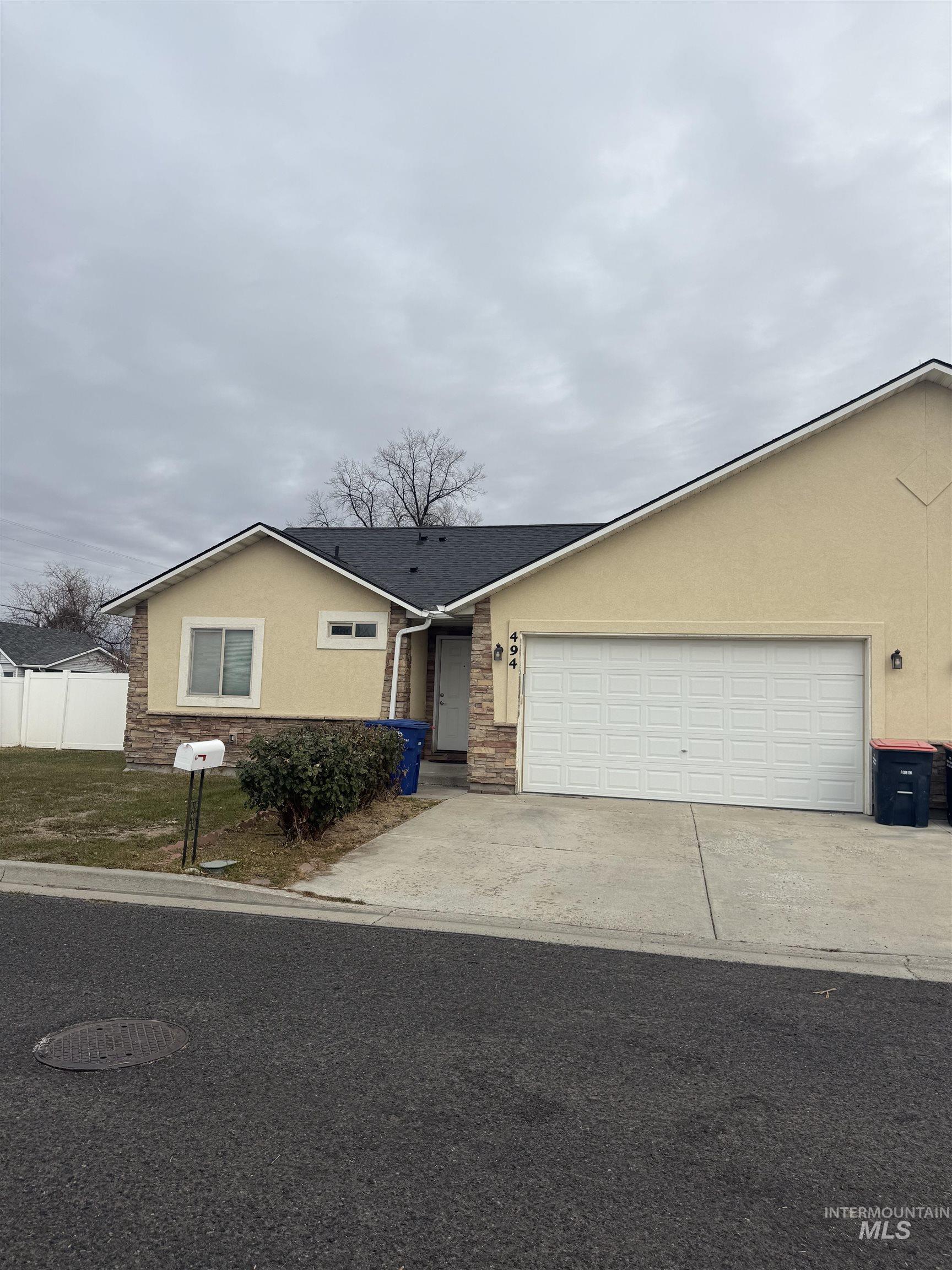 Ranch-style house featuring stucco siding, concrete driveway, and an attached garage