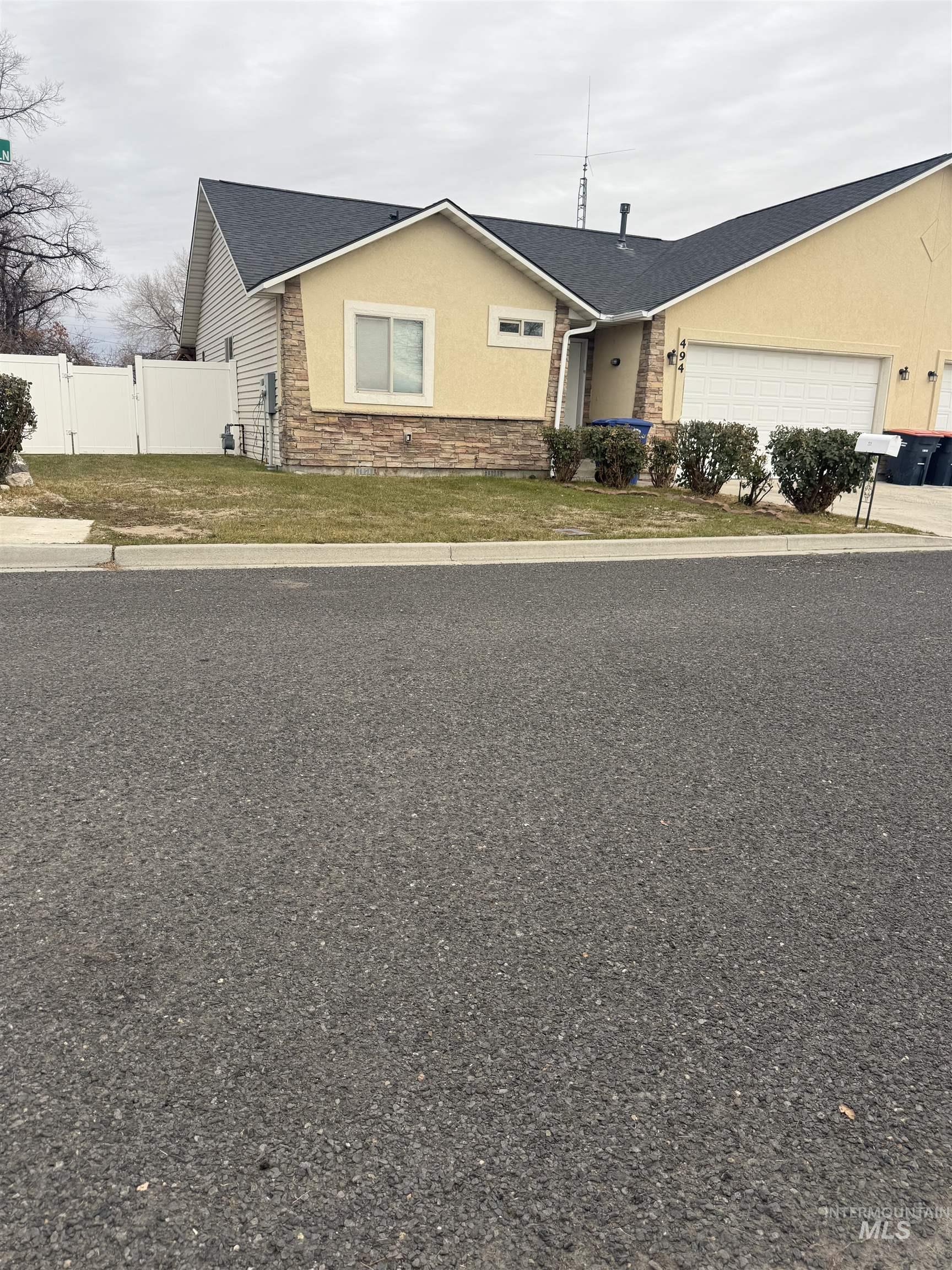 494 Adria Lane Twin Falls, ID 83301 - Photo 3 of 19 Ranch-style house with stucco siding, an attached garage, stone siding, a shingled roof, and driveway