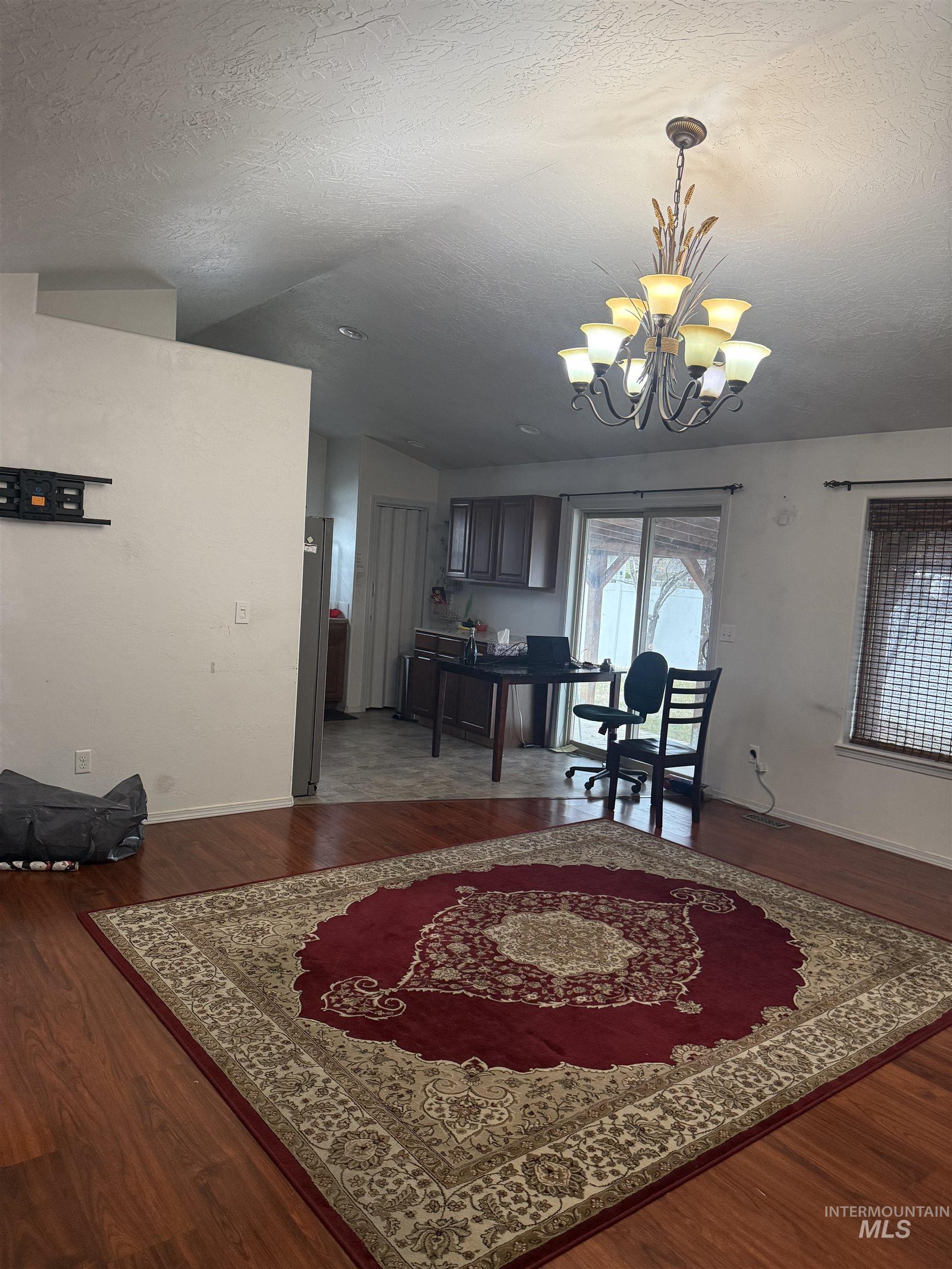 494 Adria Lane Twin Falls, ID 83301 - Photo 8 of 19 Dining room featuring a textured ceiling, a chandelier, and dark wood finished floors