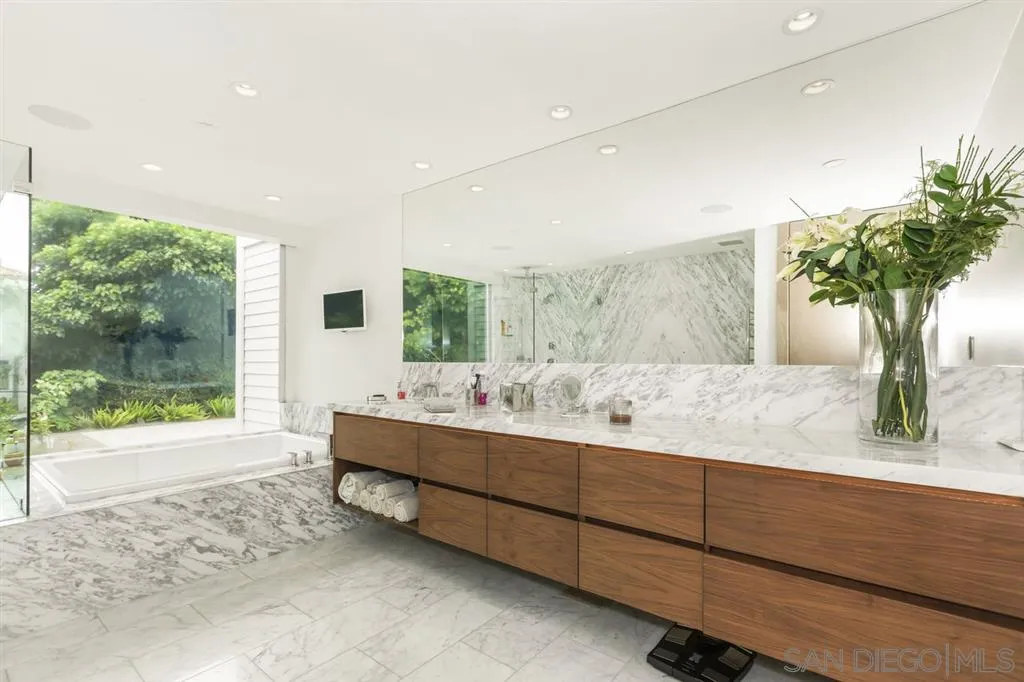 9648 Blackgold Road La Jolla, CA 92037 - Photo 11 of 25 a bathroom with a granite countertop sink a large mirror and a large window