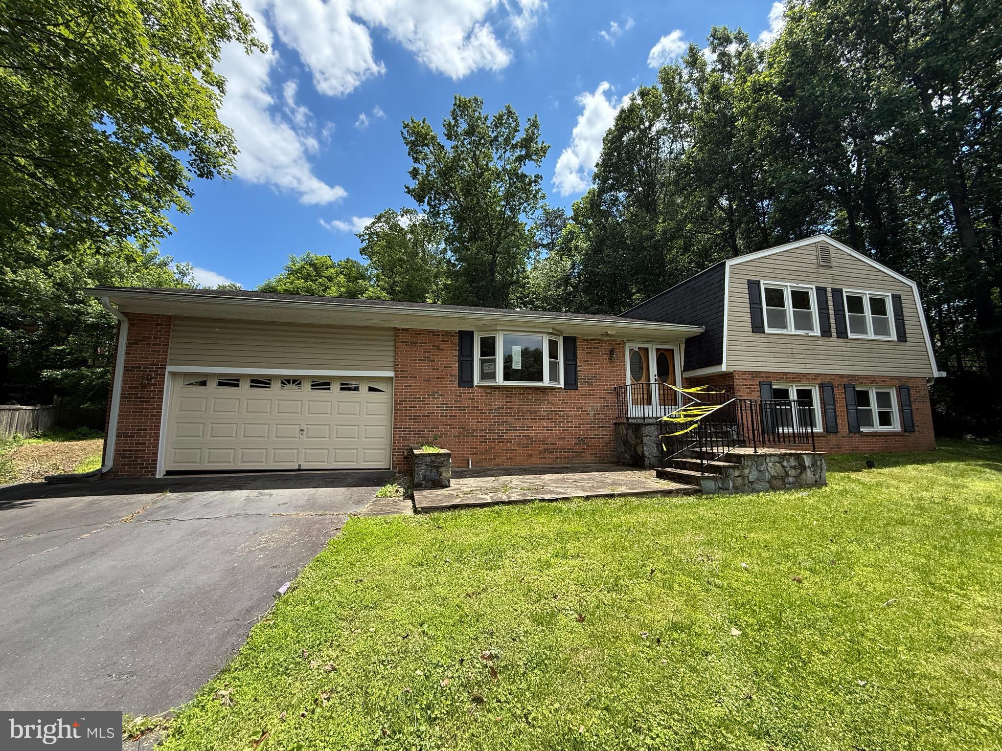 a front view of a house with a yard and trees