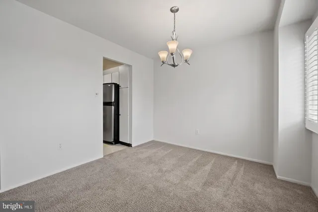 an empty room with chandelier fan