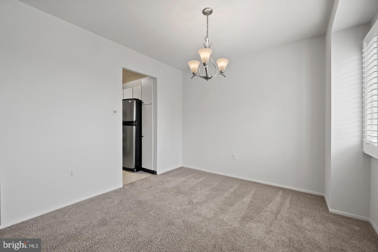 1111 University Boulevard West, Unit 815 Silver Spring, MD 20902 - Photo 7 of 14 an empty room with chandelier fan
