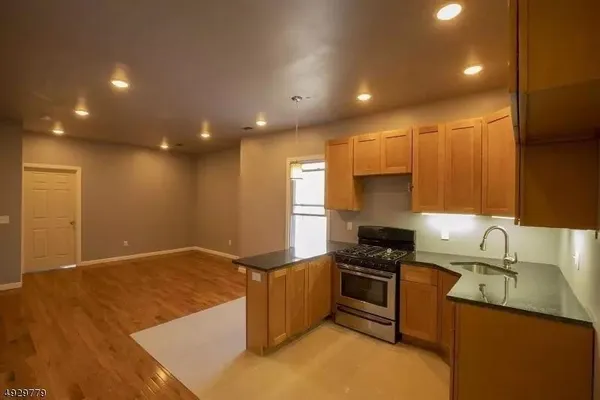 a kitchen with granite countertop a sink stainless steel appliances and cabinets