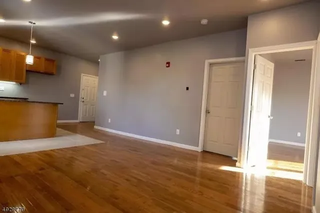 a view of an empty room with wooden floor