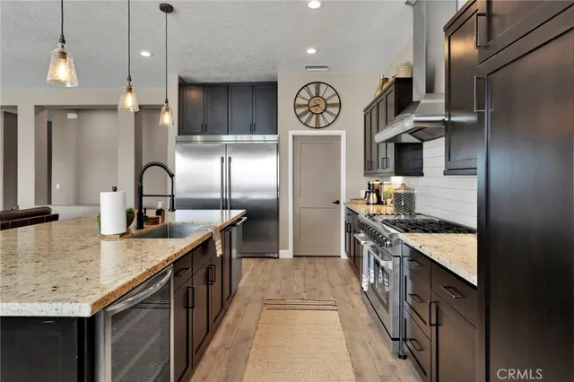 a kitchen with stainless steel appliances kitchen island granite countertop a refrigerator and a sink