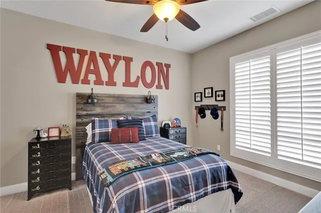 a bedroom with a bed a couch and a flat screen tv