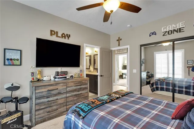 a bedroom with a bed a flat screen tv and a chandelier
