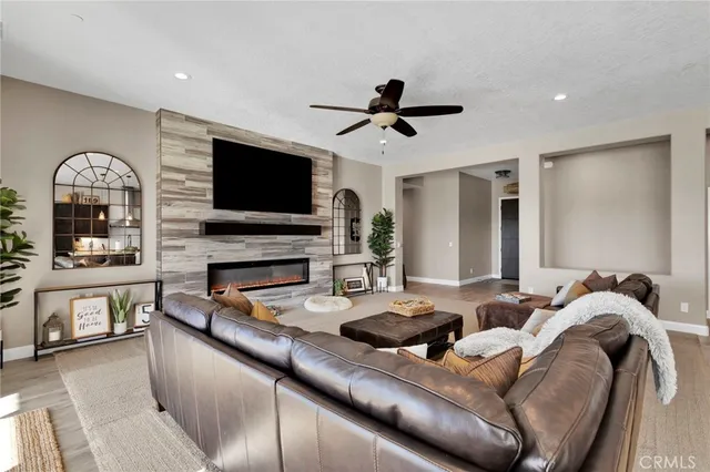 a living room with furniture a flat screen tv and a fireplace