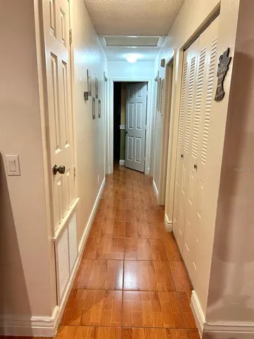 a view of a hallway with wooden floor and staircase