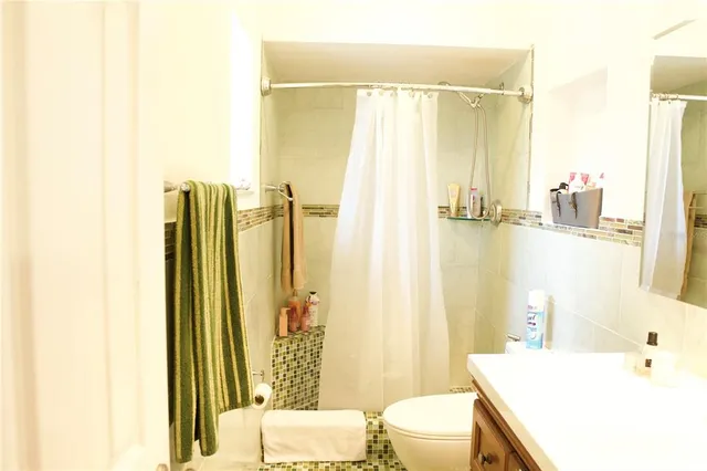 a bathroom with a sink a toilet and shower curtain