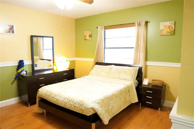 a bedroom with a bed and wooden floor